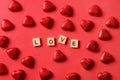 Romantic chocolate sweets as heart in red foil and text - Love. Valentine day card on red background