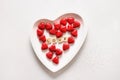 Romantic chocolate sweets as heart in red foil and text on wooden blocks - Love in white plate.
