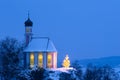 Romantic Christmas chapel with illuminated tree in snow