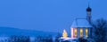 Romantic Christmas chapel with illuminated tree in snow