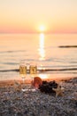 A romantic or Christmas evening on a sunny background. glare in the sea during sunset. Two glasses of champagne with grapes Royalty Free Stock Photo