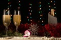 Romantic Christmas and New Year dinner of a couple in love with two glasses of champagne and a wedding ring. Red tinsel and spruce Royalty Free Stock Photo