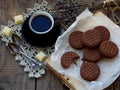 Romantic composition of chocolate cookies with white cream, cup of coffee and bouquet lavender on wooden background. Selective foc Royalty Free Stock Photo