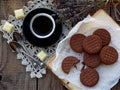 Romantic composition of chocolate cookies with white cream, cup of coffee and bouquet lavender on wooden background. Selective foc Royalty Free Stock Photo