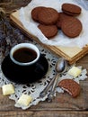 Romantic composition of chocolate cookies with white cream, cup of coffee and bouquet lavender on wooden background. Selective foc Royalty Free Stock Photo