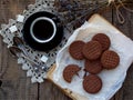 Romantic composition of chocolate cookies with white cream, cup of coffee and bouquet lavender on wooden background. Selective foc Royalty Free Stock Photo