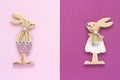 Romantic composition Pair of wooden lovers figurine rabbits on pink purple background Concept Valentine`s card Top view Flat Lay