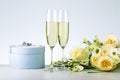 Romantic composition with two glasses of champagne, gift box and bouquet roses. Royalty Free Stock Photo