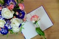 Romantic concept. Diary and rose. Bouquet of multi-colored roses on a wooden table. Top view. Layout. Place for text Royalty Free Stock Photo