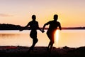 Romantic couple on the beach at colorful sunset on background Royalty Free Stock Photo