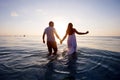 Romantic couple on the beach at colorful sunset on background Royalty Free Stock Photo