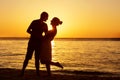 Romantic couple on the beach at colorful sunset on background Royalty Free Stock Photo