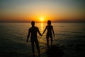 Romantic couple on the beach watching on sunset in twilight. Silhouette. Royalty Free Stock Photo