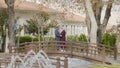 Romantic couple on bridge in park. Action. Beautiful oriental couple stands on wooden bridge in park. Adult couple Royalty Free Stock Photo