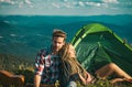 Romantic couple camping outdoors and sitting near tent. Happy Man and woman on a romantic camping vacation. Young couple Royalty Free Stock Photo