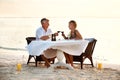 Romantic couple celebrating with wine at the beach. Shot of a mature couple enjoying a romantic dinner on the beach. Royalty Free Stock Photo