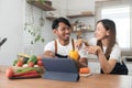 Romantic couple is cooking on kitchen. Handsome man and attractive young woman are having fun together while making Royalty Free Stock Photo