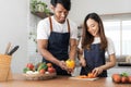 Romantic couple is cooking on kitchen. Handsome man and attractive young woman are having fun together while making Royalty Free Stock Photo