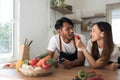 Romantic couple is cooking on kitchen. Handsome man and attractive young woman are having fun together while making Royalty Free Stock Photo