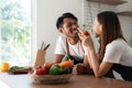 Romantic couple is cooking on kitchen. Handsome man and attractive young woman are having fun together while making Royalty Free Stock Photo