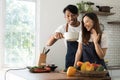 Romantic couple is cooking on kitchen. Handsome man and attractive young woman are having fun together while making Royalty Free Stock Photo