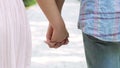 Romantic couple on date walking with hands interlocked, mutual trust, close-up