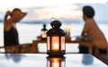 Romantic couple dating dinner blur background under candle light lantern and sunset twilight sky with clouds during beautiful gold