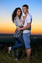 Romantic couple embrace at sunset, beautiful landscape and bright yellow sky, love tenderness concept, young adult people Royalty Free Stock Photo