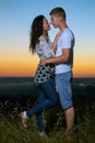 Romantic couple embrace at sunset, beautiful landscape and bright yellow sky, love tenderness concept, young adult people Royalty Free Stock Photo