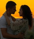 Romantic couple embrace at sunset on outdoor, beautiful landscape and bright yellow sky, love tenderness concept, young adult Royalty Free Stock Photo