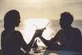 Romantic couple enjoy sunset in restaurant on the beach drinking cocktails Royalty Free Stock Photo