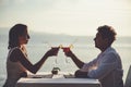 Romantic couple enjoy sunset in restaurant on the beach drinking cocktails Royalty Free Stock Photo