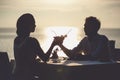Romantic couple enjoy sunset in restaurant on the beach drinking cocktails Royalty Free Stock Photo