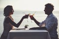 Romantic couple enjoy sunset in restaurant on the beach drinking cocktails Royalty Free Stock Photo