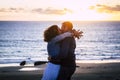 Romantic couple enjoying sunset at the beach kissing and loving each other - caucasian people have romance summer time holiday Royalty Free Stock Photo