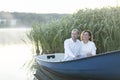 Romantic couple enjoys time sitting in boat, sailing in water. Happy smiling Caucasian man Royalty Free Stock Photo