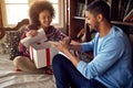 Couple Exchanging Christmas Gifts while celebrating Christmas at Royalty Free Stock Photo