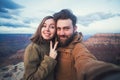 Romantic couple or friends show thumbs up and make selfie photo on travel hiking at Grand Canyon in Arizona