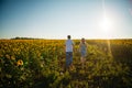 Romantic couple go and holding hands on background summer meadow sunflower sunset