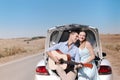 Romantic couple with guitar resting near car Royalty Free Stock Photo