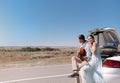 Romantic couple with guitar resting near car Royalty Free Stock Photo