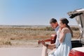 Romantic couple with guitar resting near car Royalty Free Stock Photo