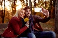 Romantic couple having fun outdoors and taking selfie with mobil