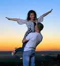 Romantic couple having fun at sunset on outdoor, beautiful landscape and bright yellow sky, love tenderness concept, young adult Royalty Free Stock Photo