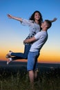 Romantic couple having fun at sunset on outdoor, beautiful landscape and bright yellow sky, love tenderness concept, young adult Royalty Free Stock Photo