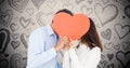 Romantic couple hiding their face behind red heart Royalty Free Stock Photo