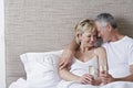 Romantic Couple Holding Champagne Flutes In Bed