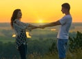 Romantic couple holding hands at sunset on outdoor, beautiful landscape and bright yellow sky, love tenderness concept, young Royalty Free Stock Photo