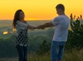 Romantic couple holding hands at sunset on outdoor, beautiful landscape and bright yellow sky, love tenderness concept, young Royalty Free Stock Photo