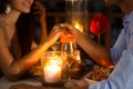 Romantic couple holding hands together over candlelight